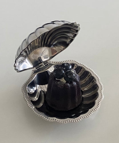 Silver shell-shaped jewelry box with a black interior on a light gray background