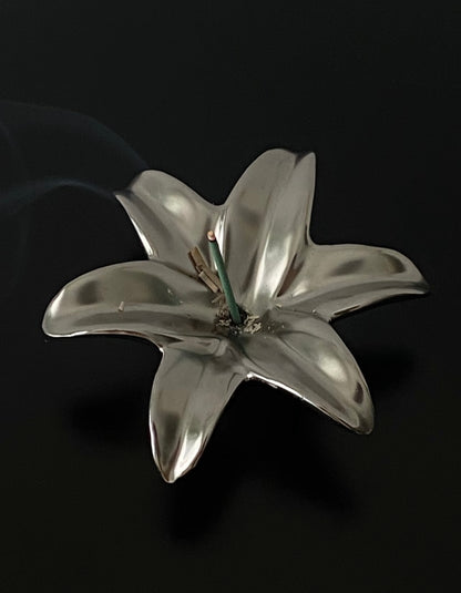 Silver lily flower brooch on a black background