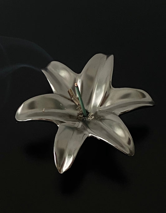 Silver lily flower brooch on a black background